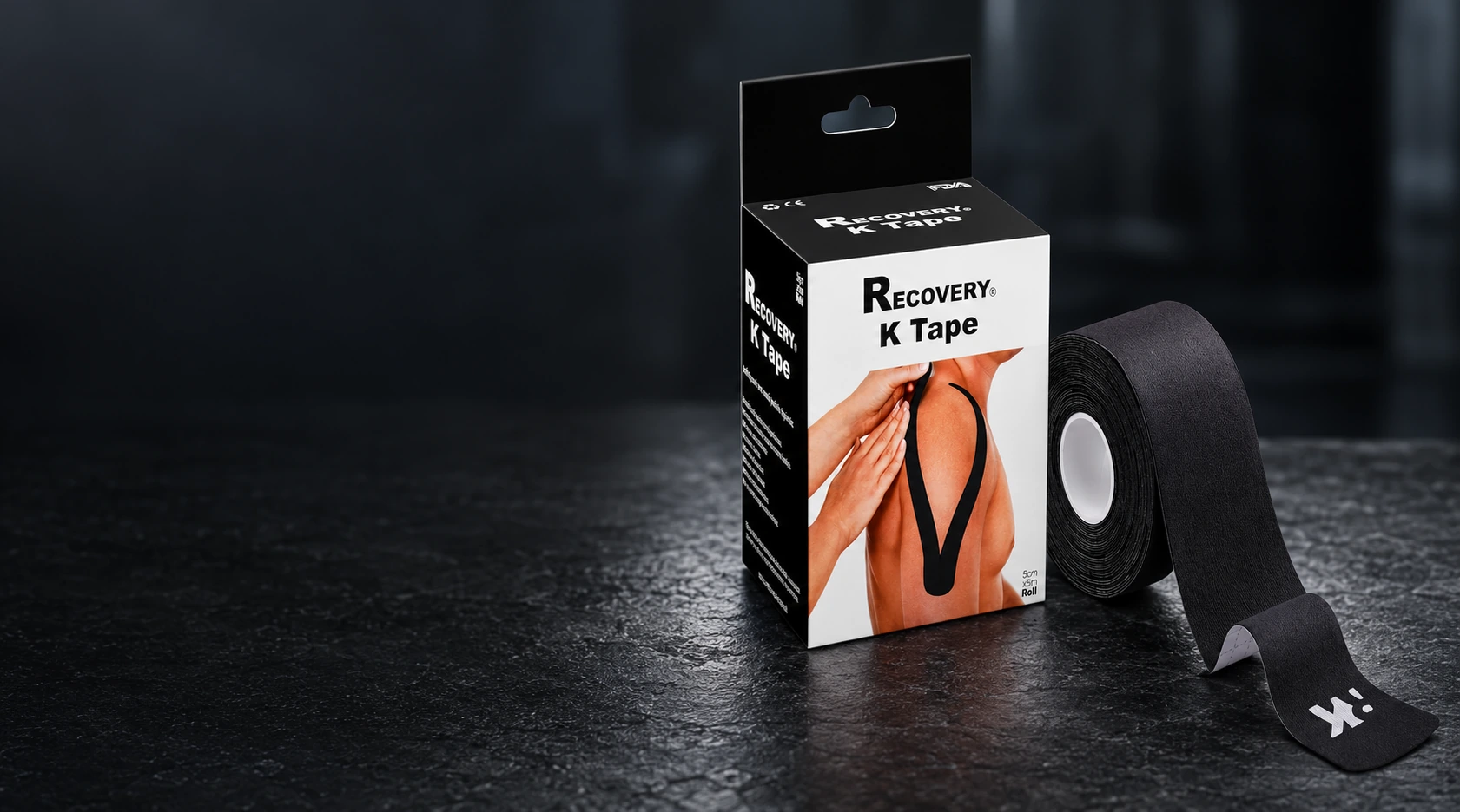 Caja y rollo negro de K Tape Recovery, con la marca blanca de su extremo